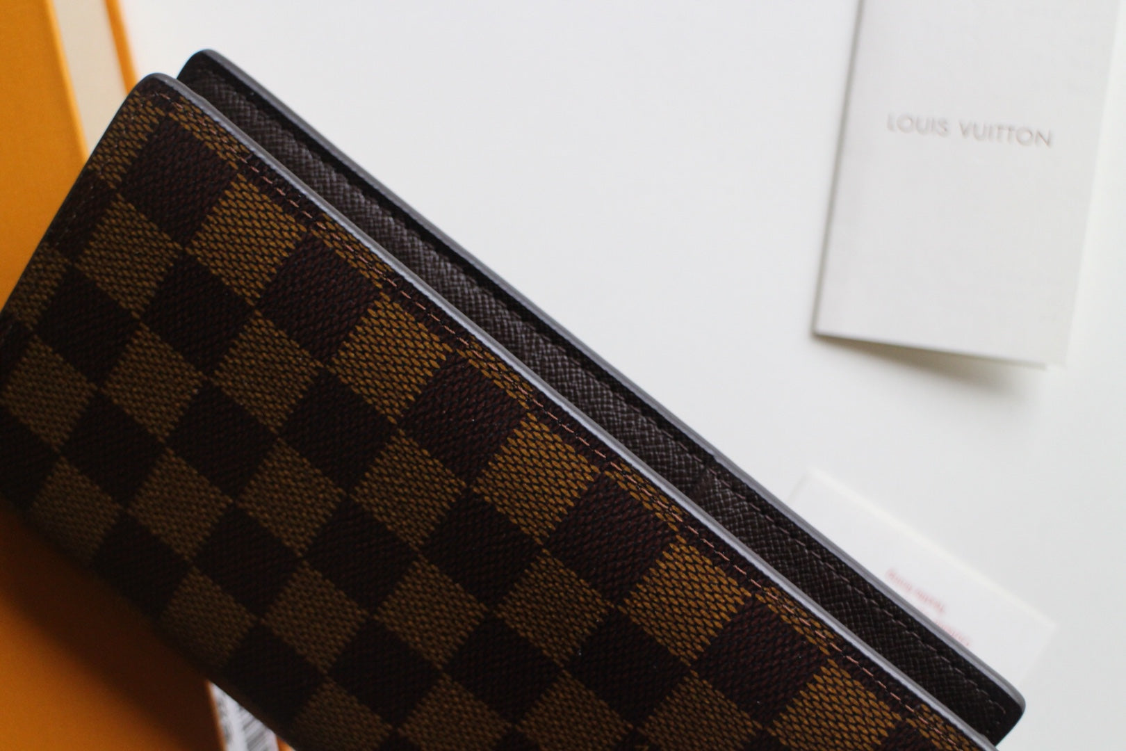 Louis Vuitton checkered wallet top edge with dark trim and brown monogram pattern