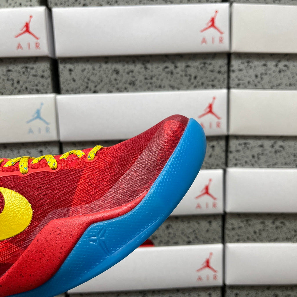 Red shoe toe with blue outsole edge and textured fabric.