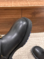 Black leather boot toe and side, stitched detail with treaded rubber outsole.