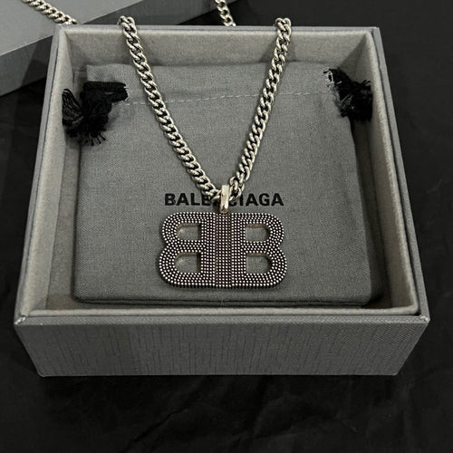 Rhinestone BB pendant necklace on gray pouch with chain and black bow accents