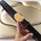 Prada belt with navy textured strap, burgundy edge, and oval gold logo buckle