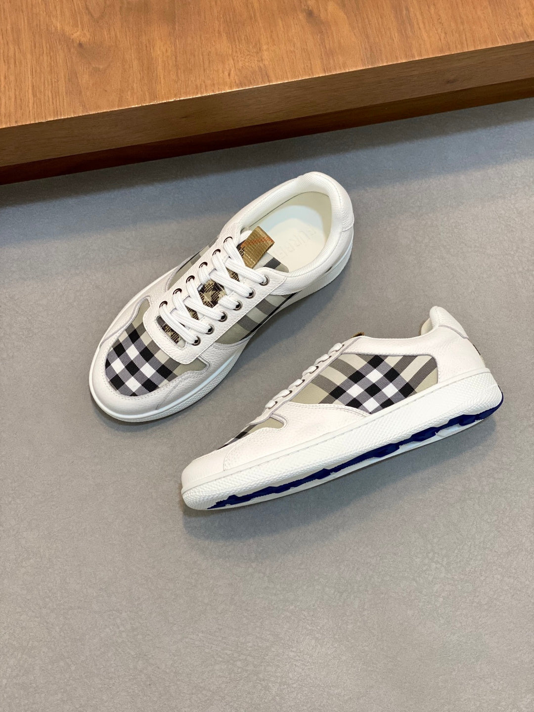 Burberry sneakers with white leather, black check quarters, and blue-tinted sole
