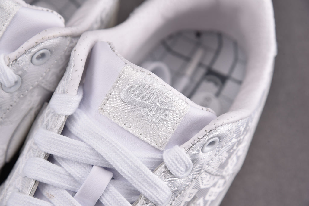 Close-up of white low-top sneakers tongue and lace-up with embossed label