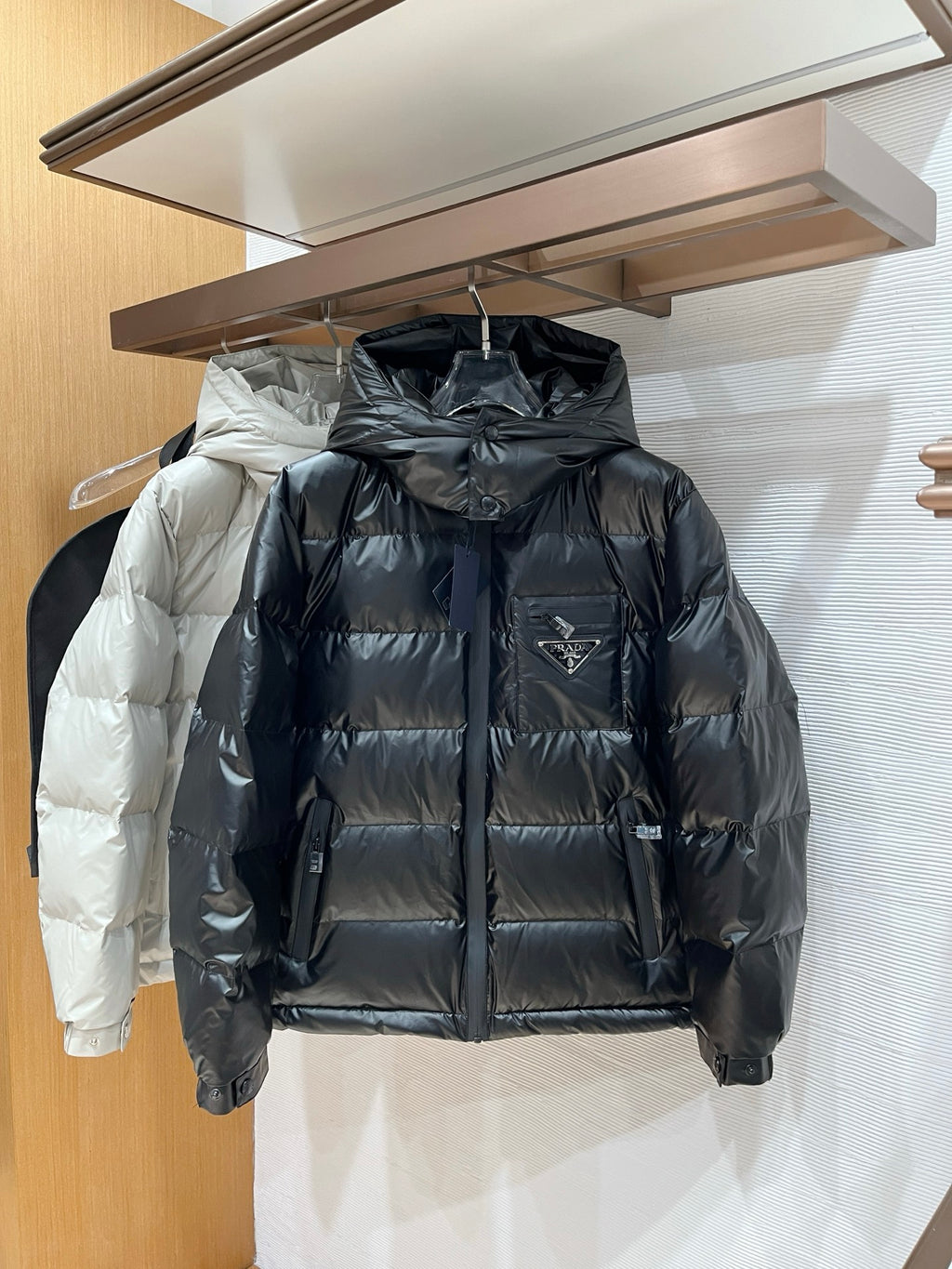 Long hooded puffer jacket in dark gray/black with full-zip front and quilted baffles