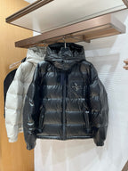 Long hooded puffer jacket in dark gray/black with full-zip front and quilted baffles