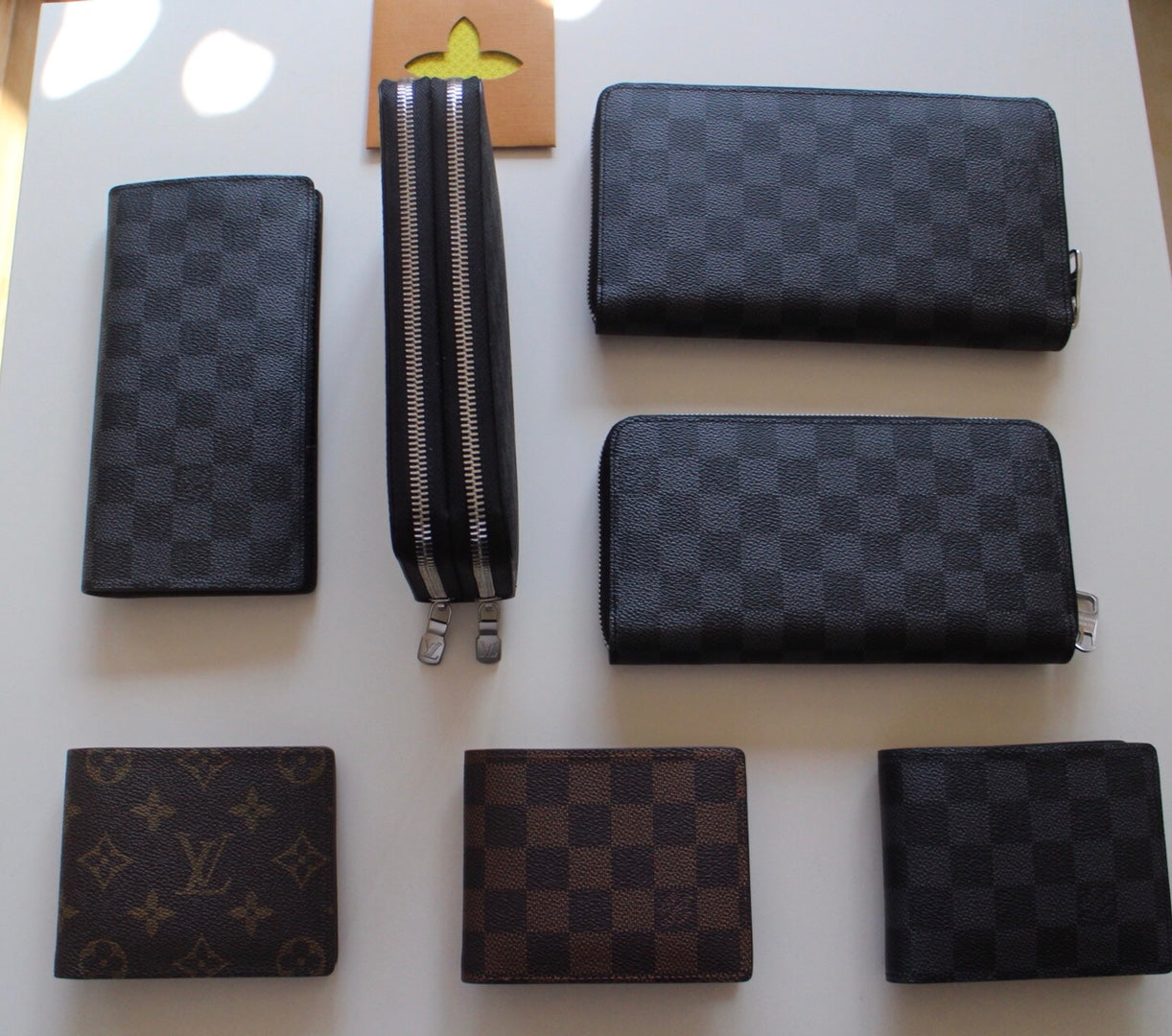 Louis Vuitton small wallets: dark checker and brown monogram zip styles, several