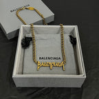 Gold Balenciaga logo necklace arched in gift box, twisted chain with logo charms