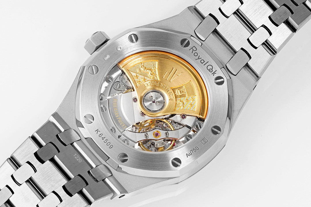 Audemars Piguet Royal Oak watch open case view showing gold-toned movement and steel bracelet.