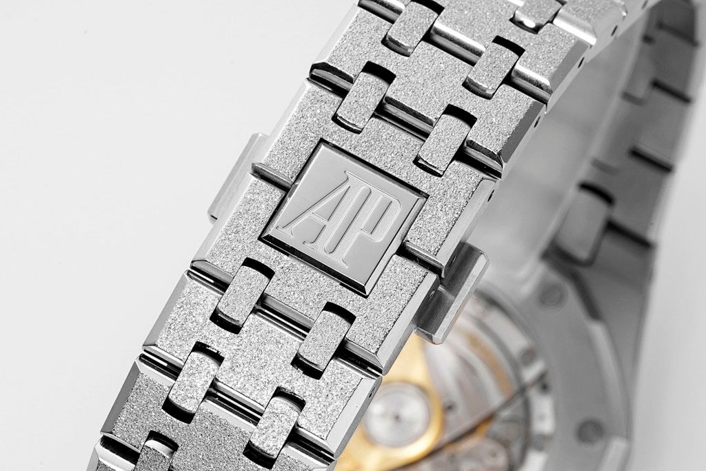 Audemars Piguet Royal Oak steel bracelet close-up with textured links and AP logo plate.