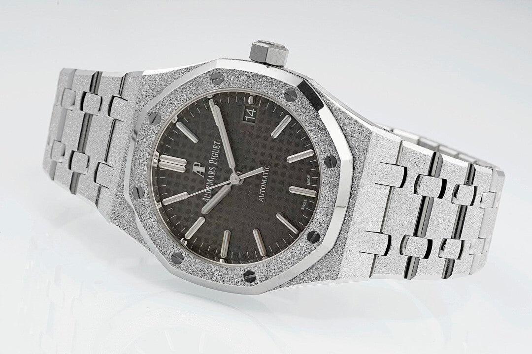 Audemars Piguet Royal Oak watch with dark dial, silver bracelet, and beveled octagonal bezel.