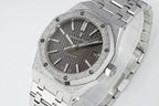 Audemars Piguet Royal Oak watch close-up with black textured dial, silver bezel, and bracelet links.