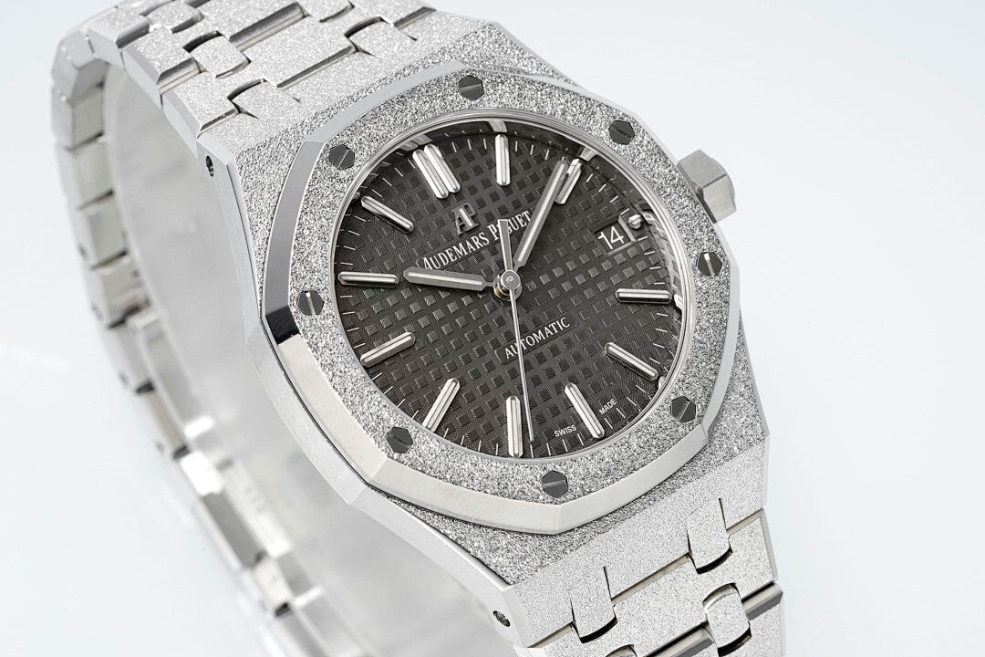 Audemars Piguet Royal Oak watch angled close-up with black dial, silver octagonal bezel, steel band.