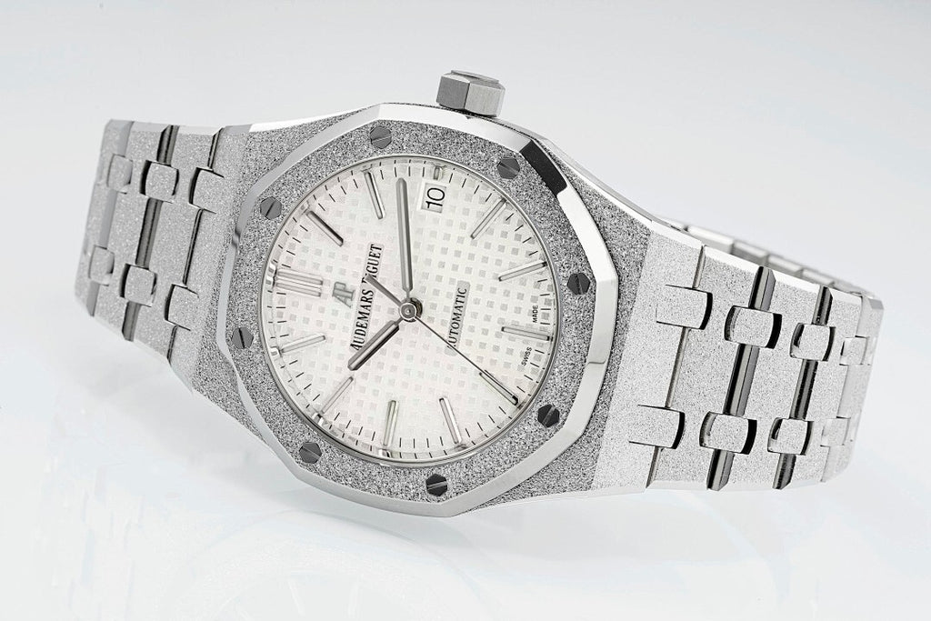 Audemars Piguet steel watch with white dial, baton hands, and link bracelet