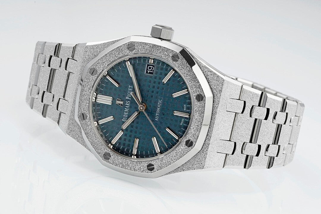 Audemars Piguet watch with textured blue dial, silver links, and crown at 3 o'clock