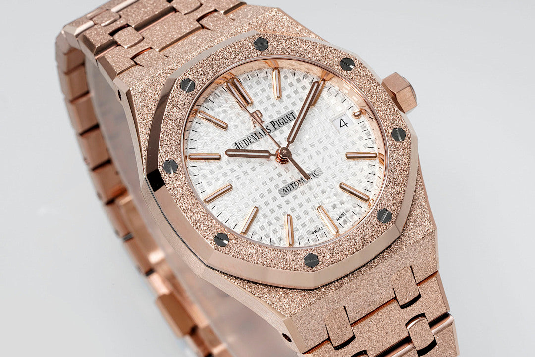 Close-up of rose gold-toned wristwatch bezel, white dial, and metal link bracelet