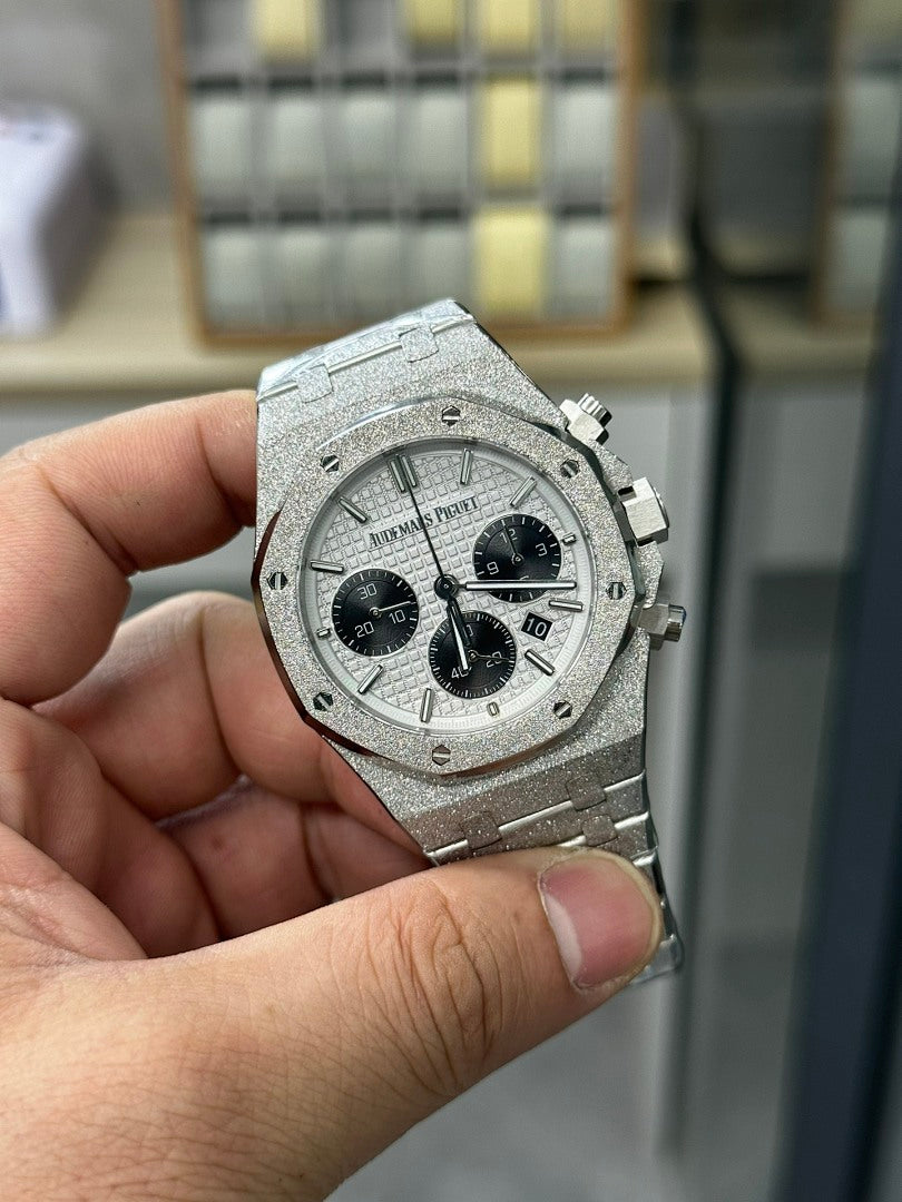 Steel chronograph watch front view with gray dial, black subdials and pushers