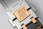 Two-tone bracelet component with engraved AP plaque on metal links.