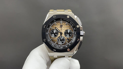 Luxury sports watch with black dial, gold-toned subdials, silver bracelet
