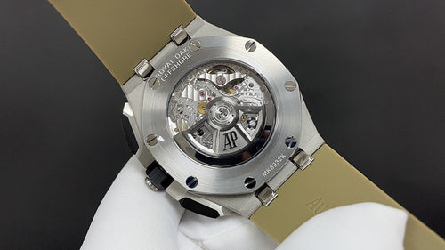 Luxury watch caseback with visible mechanical movement and AP emblem