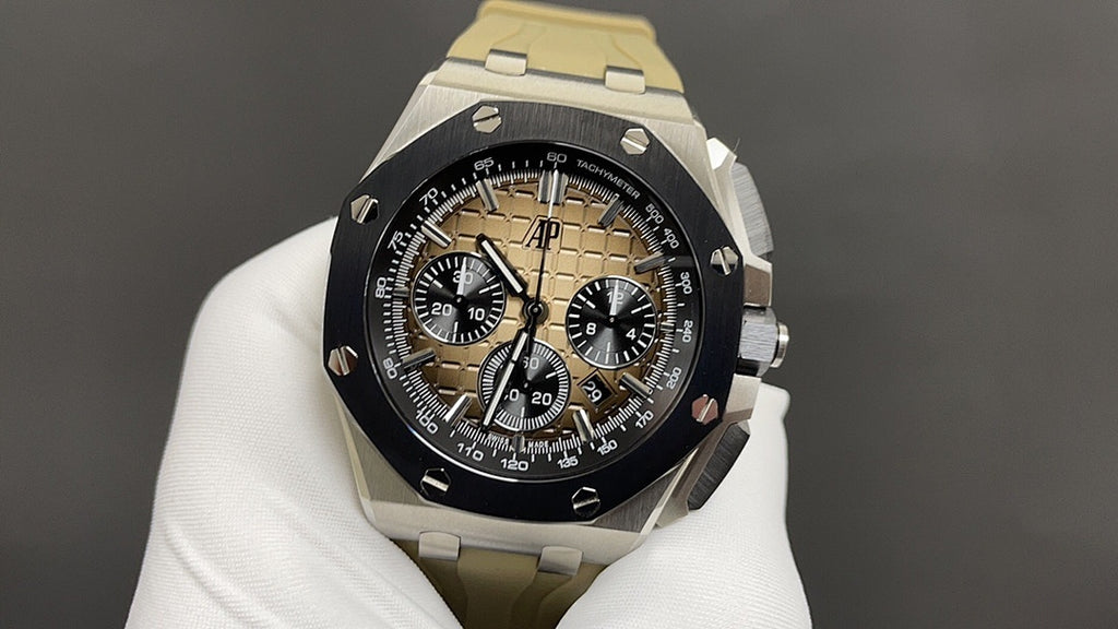 Luxury sports watch with black dial and tan subdials, silver bracelet