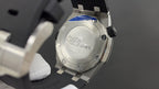 Stainless steel watch case back with screw details and engraved center plate.