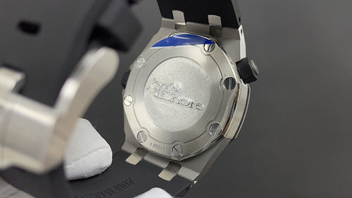 Stainless steel watch case back with screw details and engraved center plate.