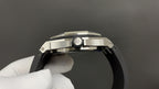 Stainless steel watch case side view with crown and polished bezel surface.