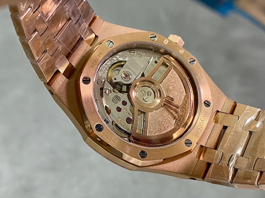 Rose gold watch caseback with exposed mechanical movement and brushed metal finish