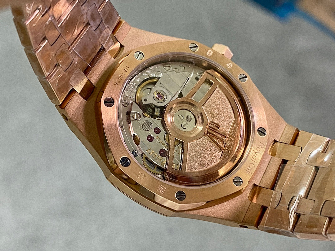 Rose gold watch caseback with exposed mechanical movement and brushed metal finish