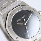 Audemars Piguet watch close-up with black dial, baton hands, stainless bezel