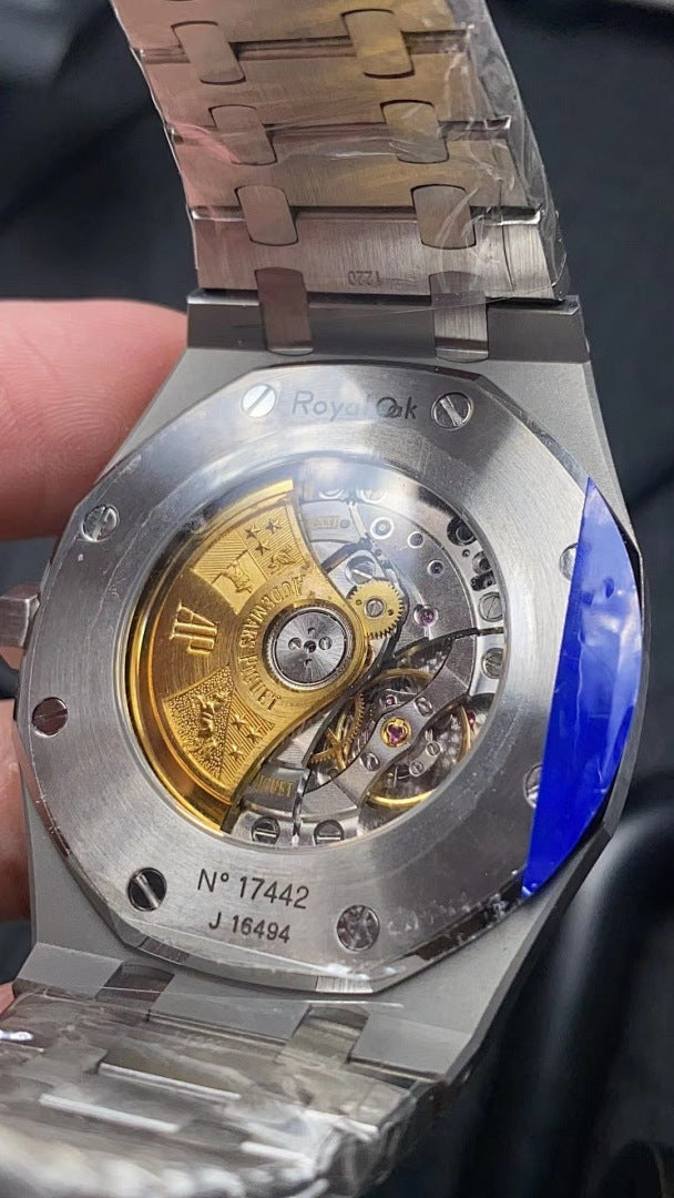 Audemars Piguet watch open caseback showing gears and a gold-toned balance wheel.
