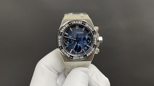 Stainless steel wristwatch with blue chronograph dial and diamond-style bezel, on glove