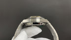 Stainless steel watch case from above, with faceted bezel and bracelet links