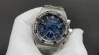 Stainless steel wristwatch with blue chronograph dial, metal bracelet, on glove