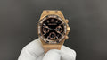 Gold Royal Oak wristwatch with black dial, gem-set bezel, and chronograph subdials