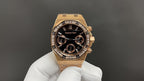 Gold Royal Oak wristwatch with black dial, gem-set bezel, and chronograph subdials