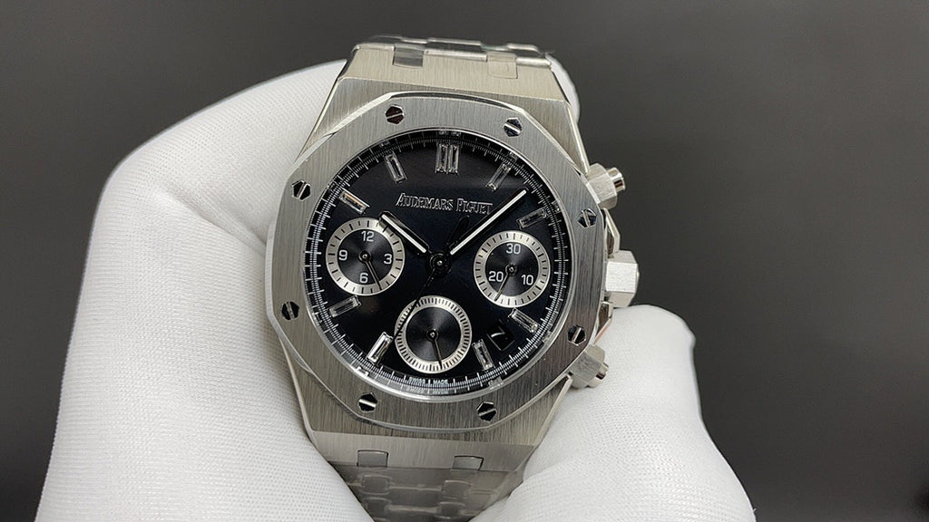 Audemars Piguet watch front view with black dial, tachymeter ring, subdials, steel bracelet.