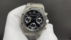 Audemars Piguet watch front view with black dial, tachymeter ring, subdials, steel bracelet.
