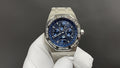 Audemars Piguet watch with blue dial and stainless steel bracelet, shown on glove.