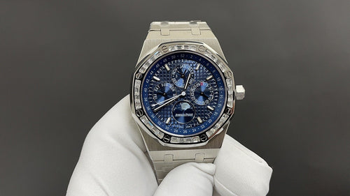 Audemars Piguet watch with blue dial and stainless steel bracelet, shown on glove.
