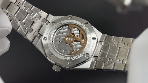 Audemars Piguet watch caseback with visible movement and stainless bracelet links.