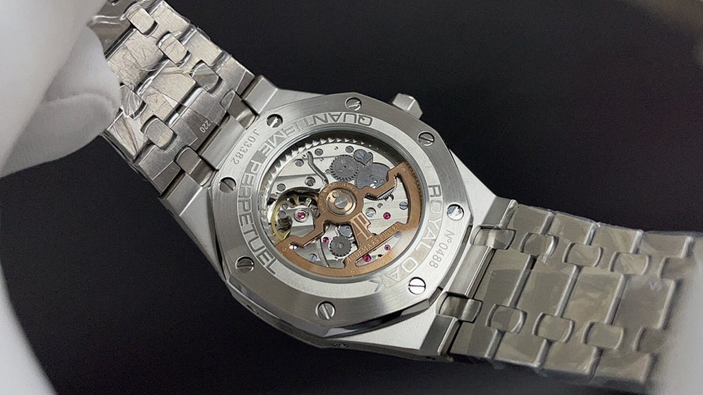 Stainless steel wristwatch showing open caseback movement and metal bracelet