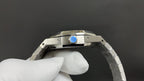 Stainless steel watch case with bracelet links, side view with blue emblem