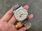 Stainless steel wristwatch with silver dial, black hands, and link bracelet