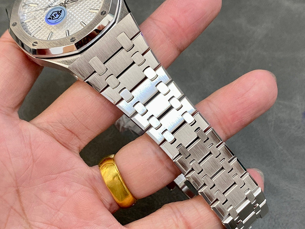 Stainless steel bracelet and watch case close-up with white dial and logo