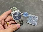 Audemars Piguet steel watch on hand with blue dial and date window at 3