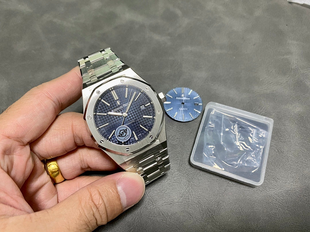 Audemars Piguet steel watch on hand with blue dial and date window at 3
