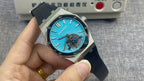 Audemars Piguet watch with turquoise dial, skeleton details, and black rubber strap