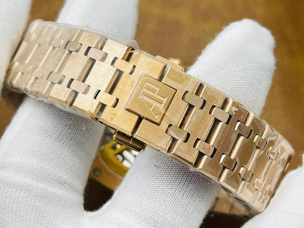 Gold-tone metal bracelet link view for a luxury wristwatch, folded on white cloth
