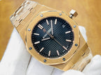 Gold-tone luxury wristwatch with dark blue dial, baton markers, and crown at top